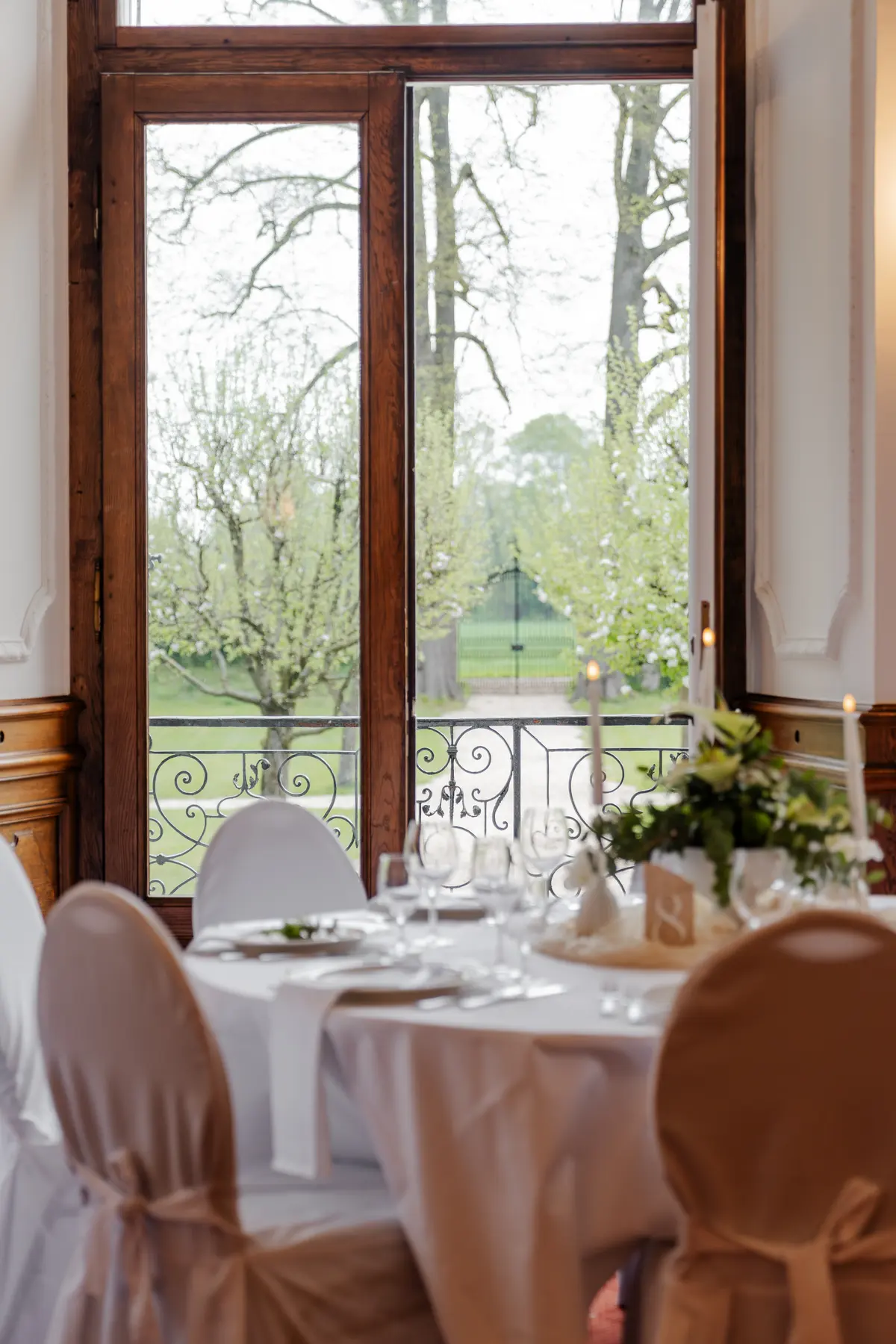 Festlich gedeckte Tafel am Fenster mit Blick in den Park